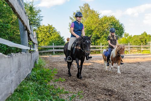 Kinder reiten Ponys in der Manege von Reiterhof von Theresia Burger in Waltenhofen-Herzmans am Niedersonthofener See im Oberallgäu